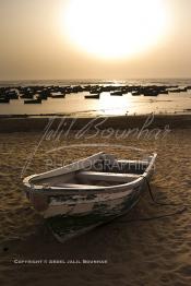 Image du Maroc Professionnelle de  Un fabuleux coucher de Soleil sur les rocher et les barques du port de Souiria Lekdima un village de pêcheurs, situé à 30 km au sud de Safi au Maroc. Ce merveilleux site réuni la mer la forêt et l'embouchure du fleuve Tensift avec l'océan Atlantique, Dimanche 12 Août 2012. (Photo / Abdeljalil Bounhar)